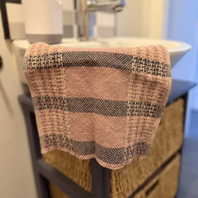 Dégustez le charme de l'artisanat d'art avec cet essuie-mains unique, tissé à la main par Line PARERA (L'Échoppe de Linette). Conçu en lin français (95%) et coton, il allie une absorption maximale à un design poétique aux rayures Latte, Paon et vieux rose. Une pièce écoresponsable exclusive.