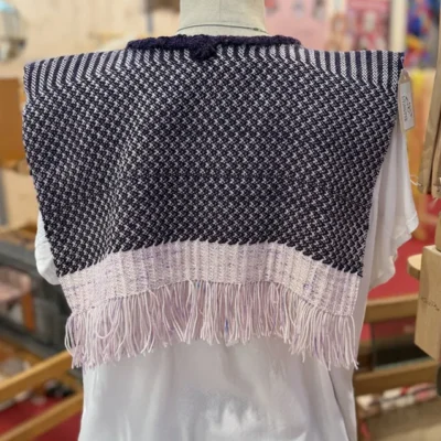 Sublimez vos tenues avec ce plastron bohème-chic en taille unique, tissé main sur métier à bras par Line PARERA. Confectionné en 100 % laine Mérinos d’Arles et coloré aux teintures naturelles, il arbore des textures géométriques violettes et écrues. Une pièce écoresponsable unique signée L’Échoppe de Linette.